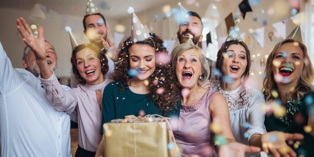 A portrait of multigeneration family with presents on a indoor birthday party.