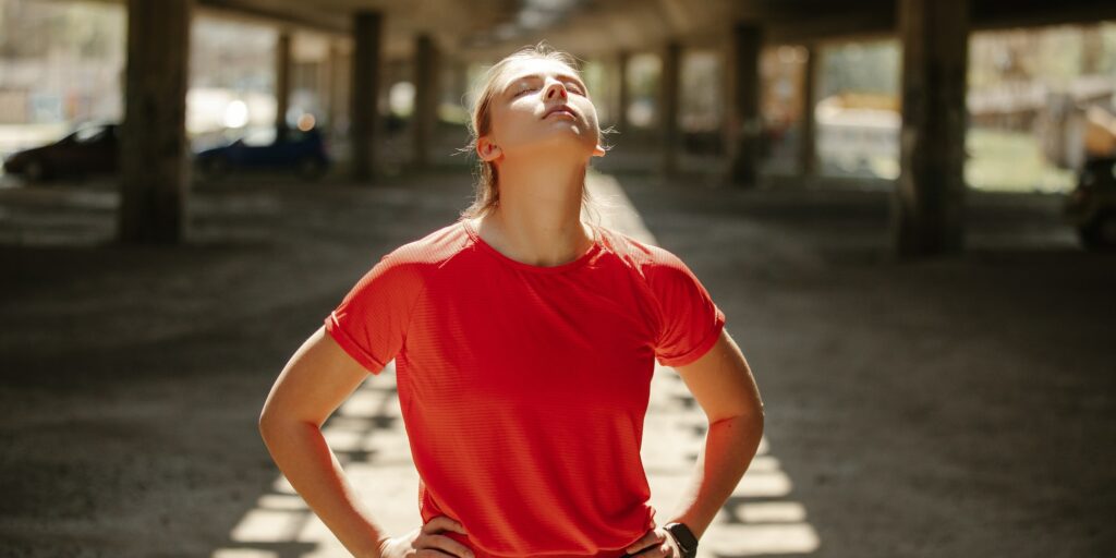 A tired fitness girl takes a breath and enjoys a break before a new series of exercises.