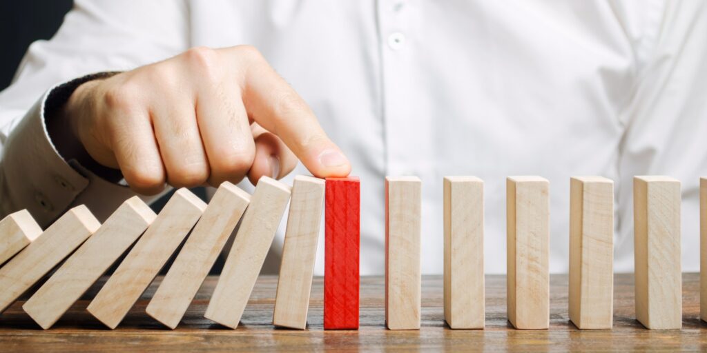 Businessman stops domino falling