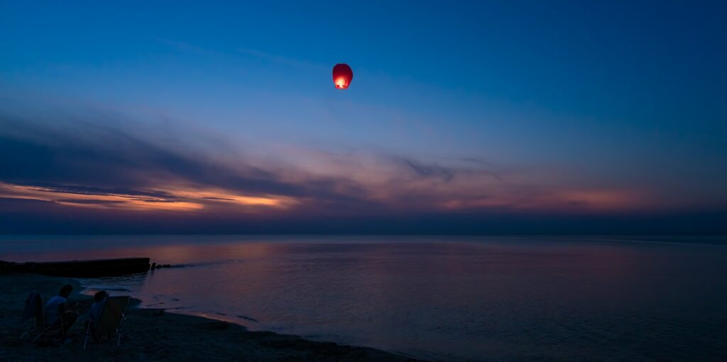 Chinese lantern flying over the calm sea at night