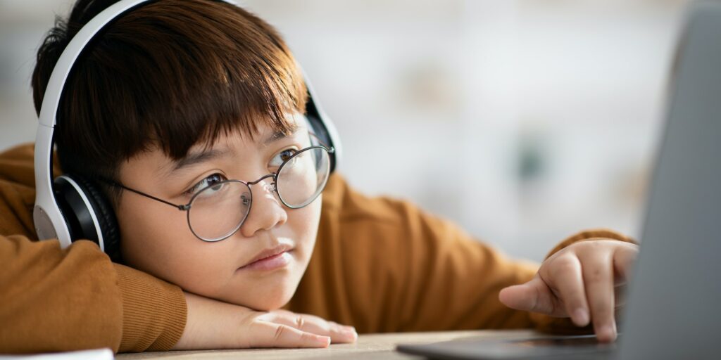 Closeup of bored plump chinese teenager studying online