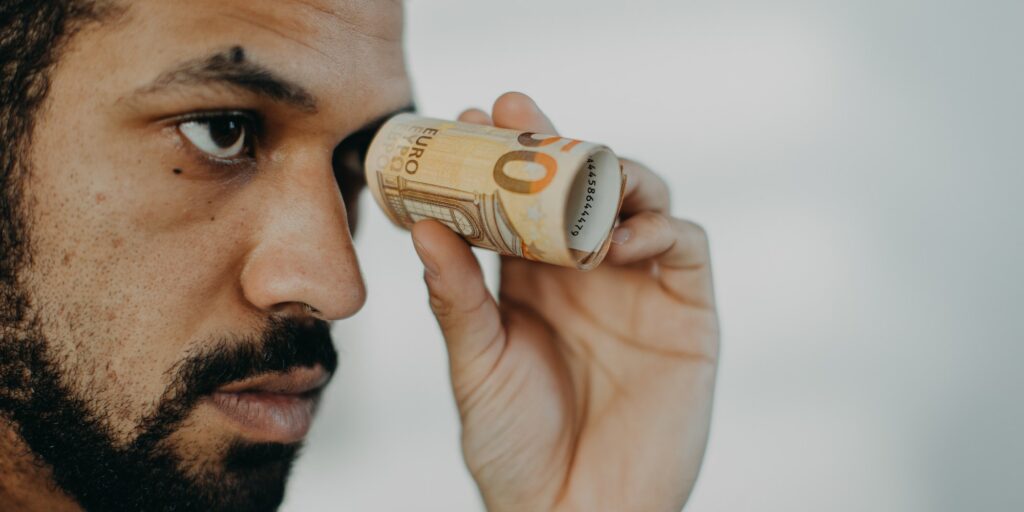 Depressed businessman man holding banknotes in a tube, inflation concept.