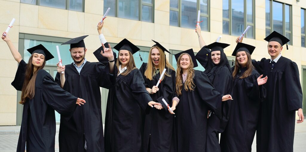 graduate students in black student robes and square hats are happy to receive diplomas and finish