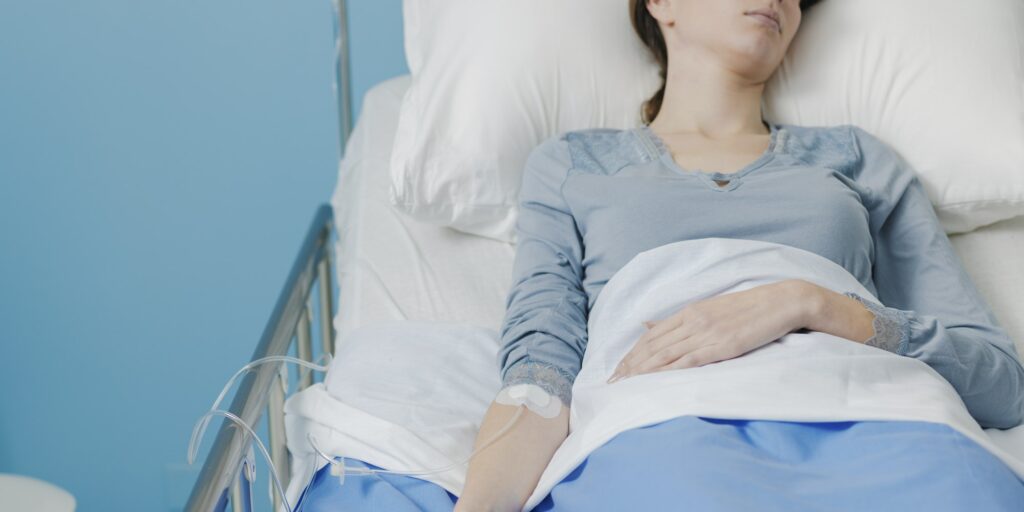 Patient in a hospital bed with IV drip