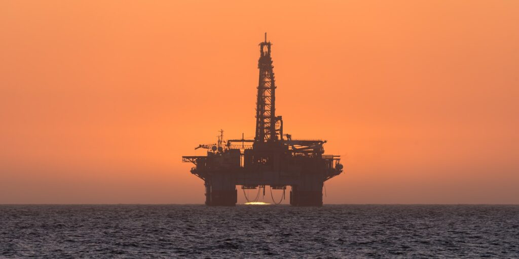 Sun setting behind oil drilling platform at Longbeach in Namibia