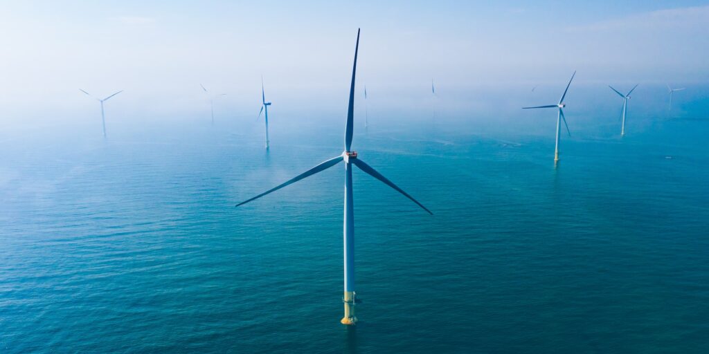 Wind turbine. Aerial view of wind turbines or windmills farm field in blue sea in Finland.