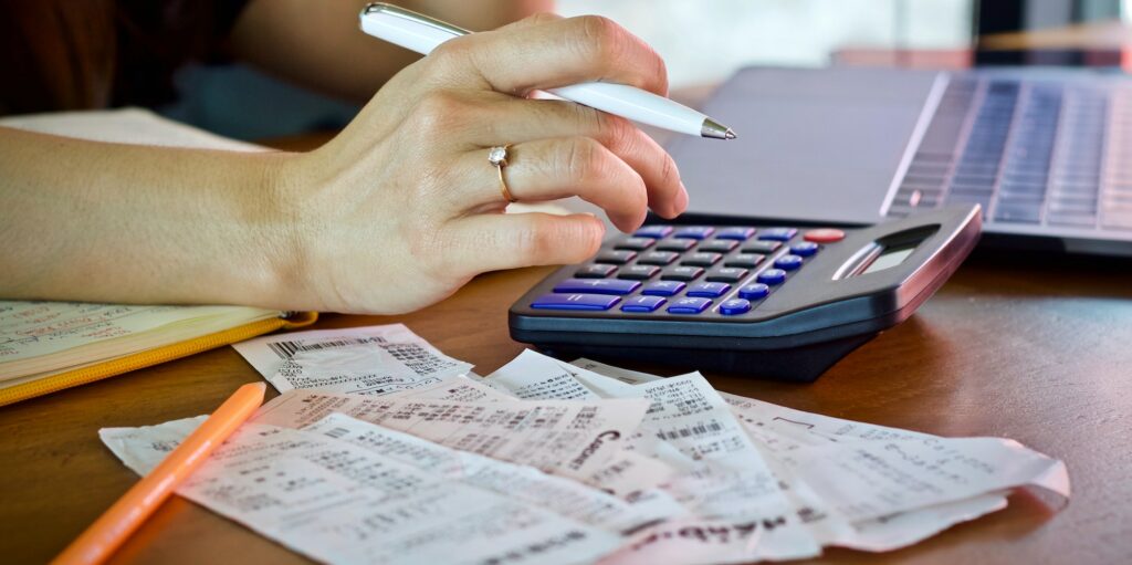woman holding bill using calculator and calculate cost bill and payment