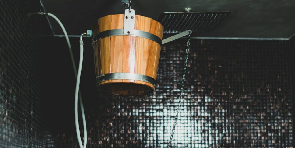 Beautiful Woman Under the Ice Cold Shower Bucket