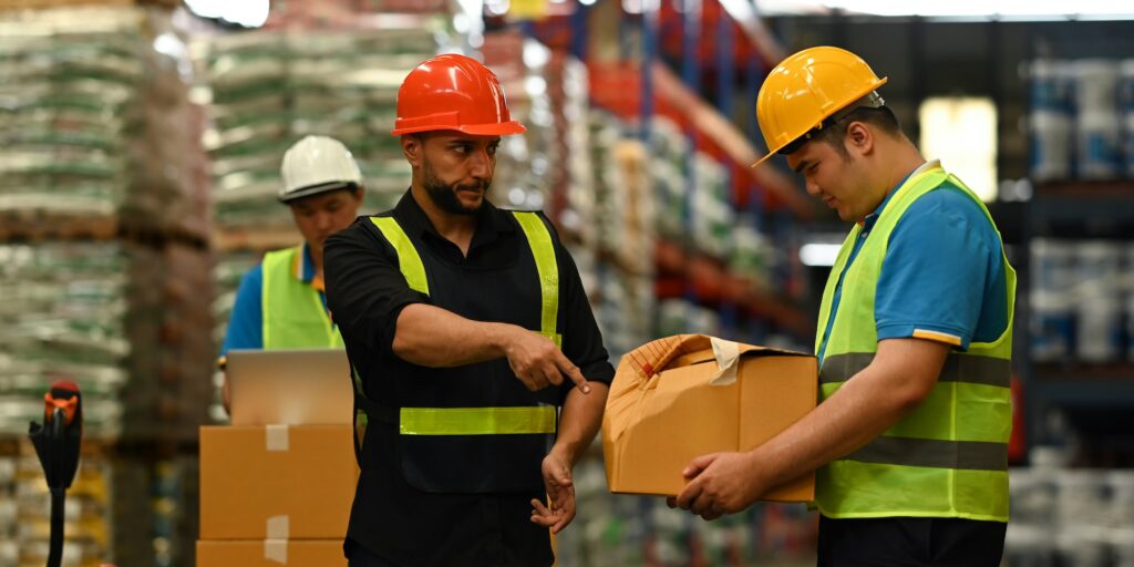 Shot of male manager scolding young intern with bad work results, damaged cardboard box.