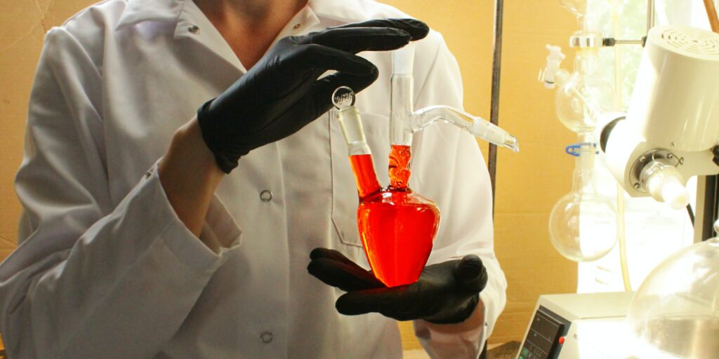 a chemist with a heart-shaped flask. analytical, research work in the laboratory, syntheses
