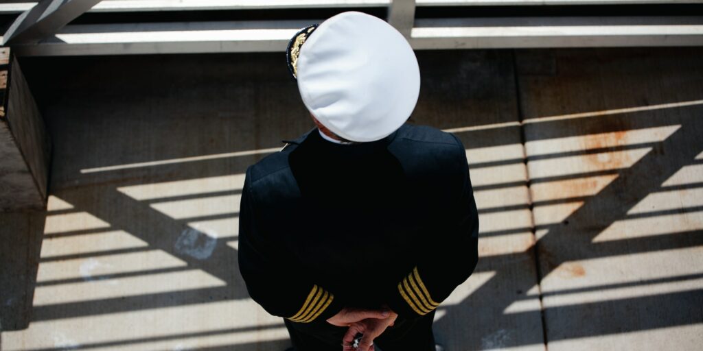 Ship captain from above on the pier in uniform on sunny day