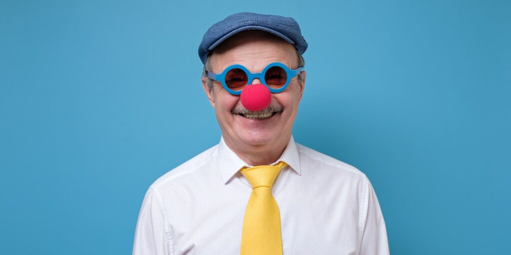 Young bearded businessman with clown nose isolated on white background