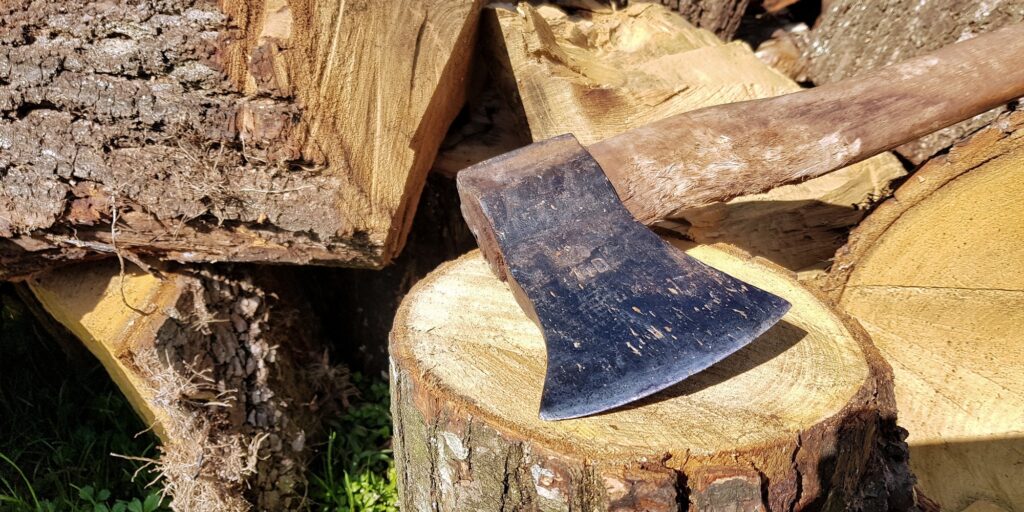 Close-up photo of axe on tree stump.