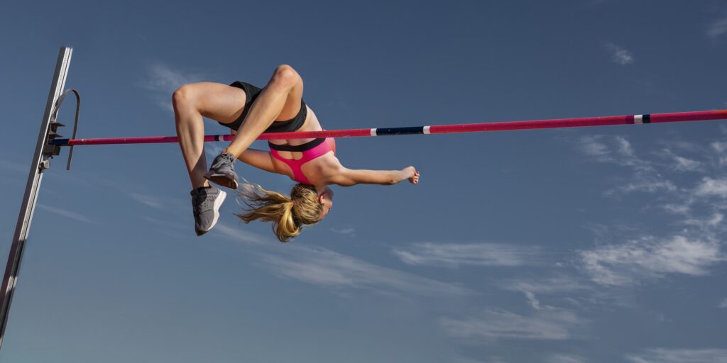 Female high jumper, worm's eye view