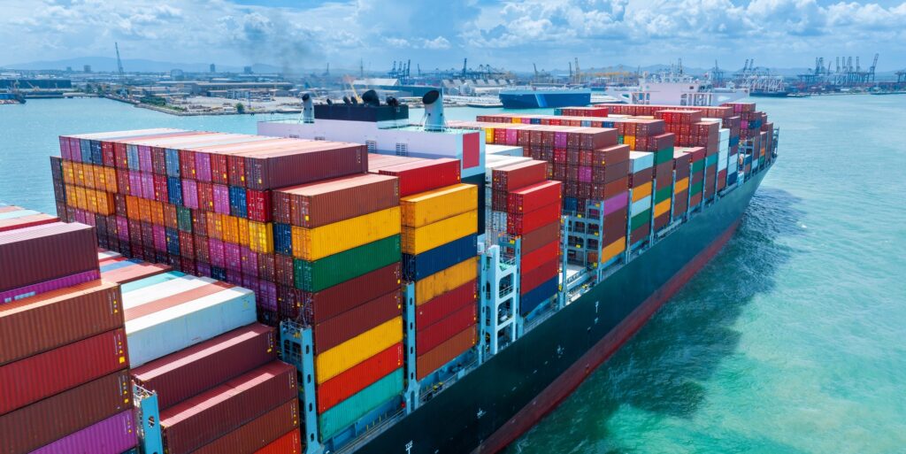 Stern of large cargo container ship import export container box on the ocean sea on blue sky