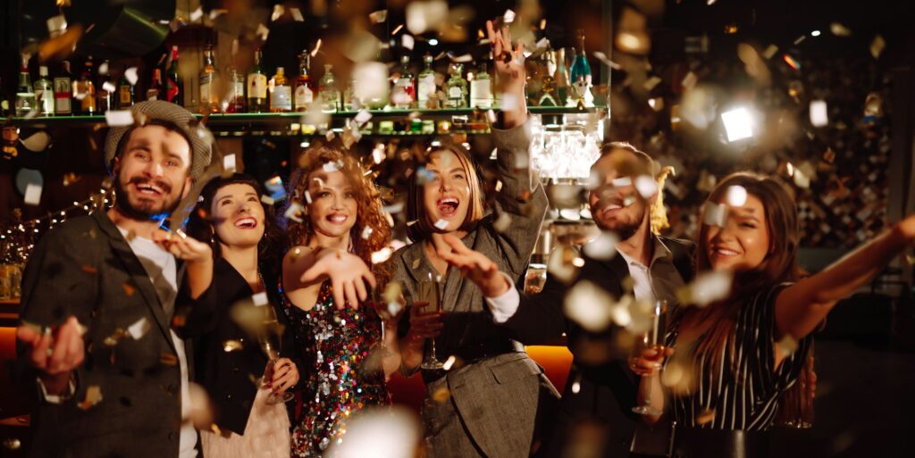 Happy friends throwing confetti and jumping while enjoying party Confetti is fun. Party, celebration