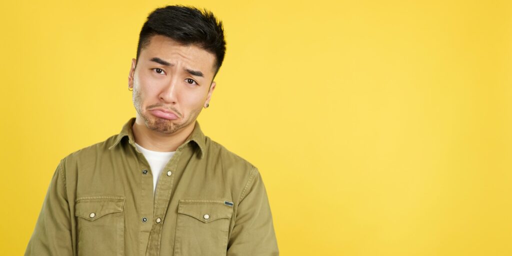 Sad handsome chinese man looking at camera