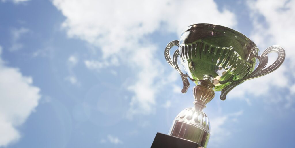 Holding up a trophy cup as a winner