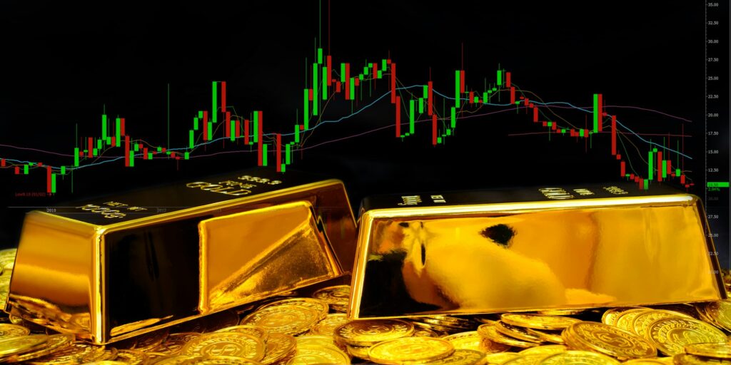 Gold bullion on pile gold coins at trading chart background