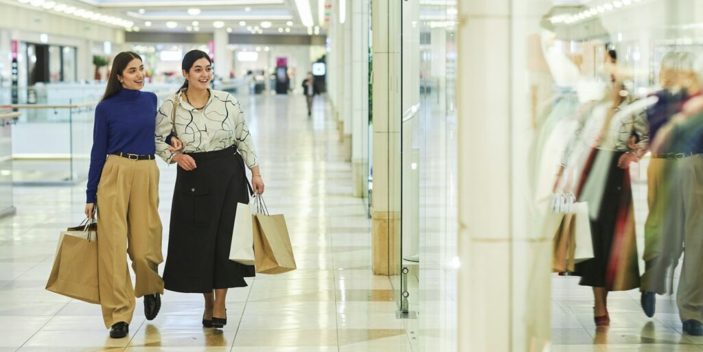Two Smiling Women Walking in Shopping Mall