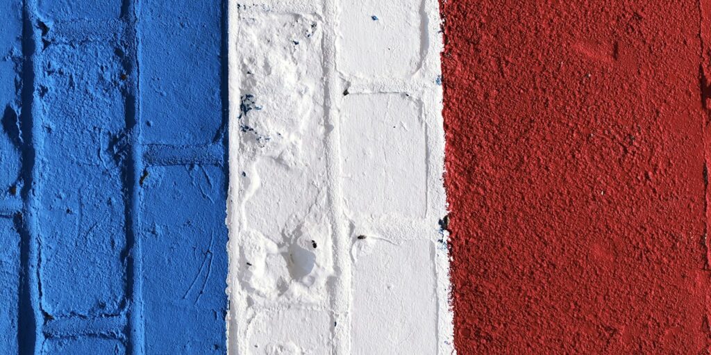 Brick wall painted blue white and red colors of a flag of France
