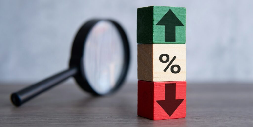 Magnifying glass and wooden blocks with percentage sign, up and down icon.