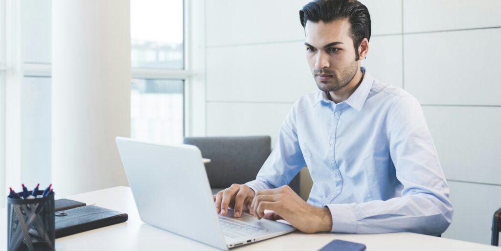Young indian businessman using computer