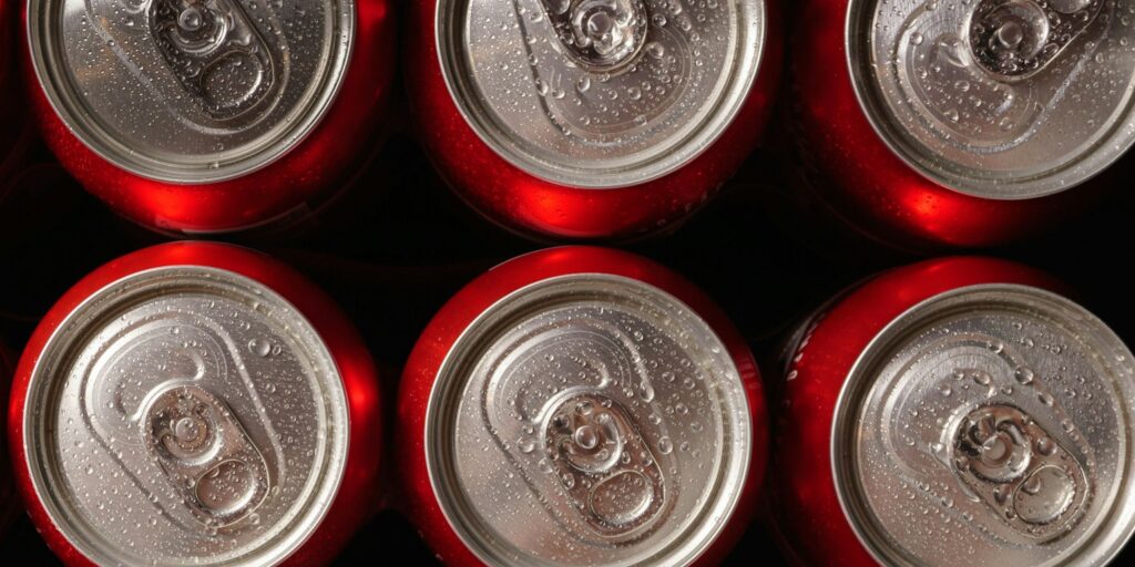 group of beer cans with water drops with black background