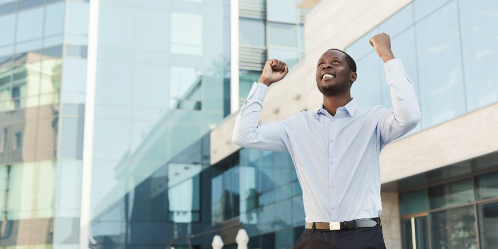 Happy excited businessman celebrate. Winner, black man outdoors