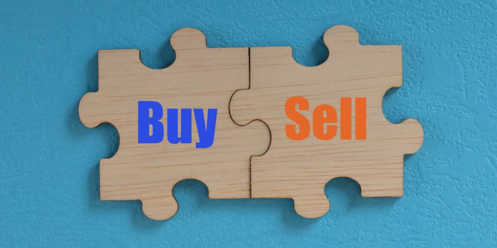 Wooden jigsaw puzzle with text BUY and SELL.