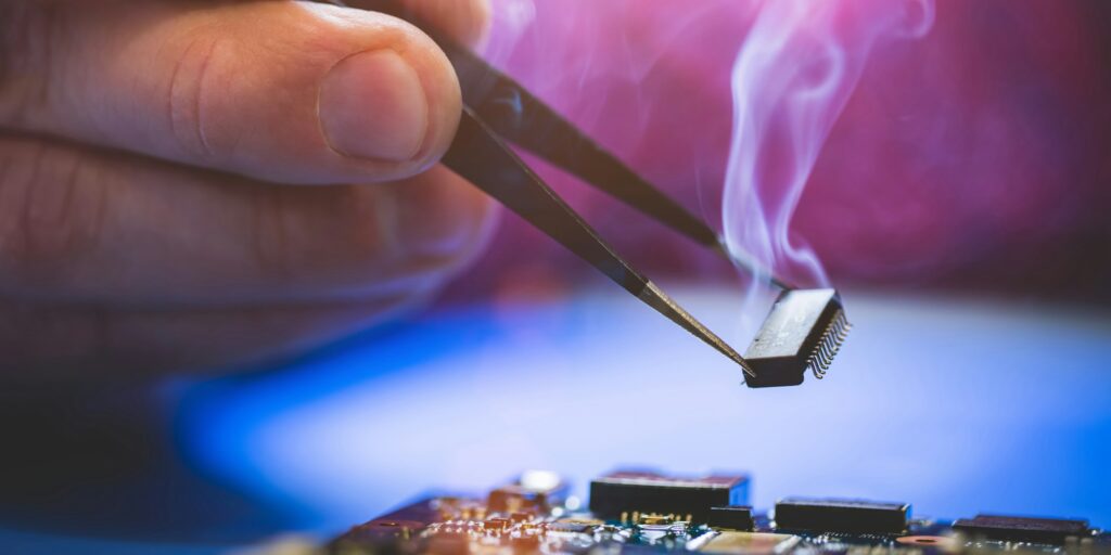 Man holding chip over the computer CPU board.