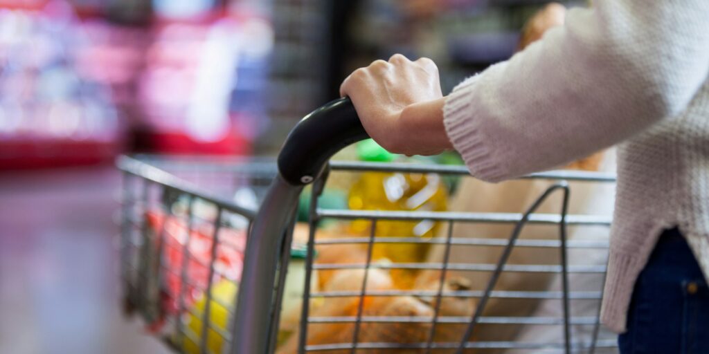 Woman holding groceries in shopping cart