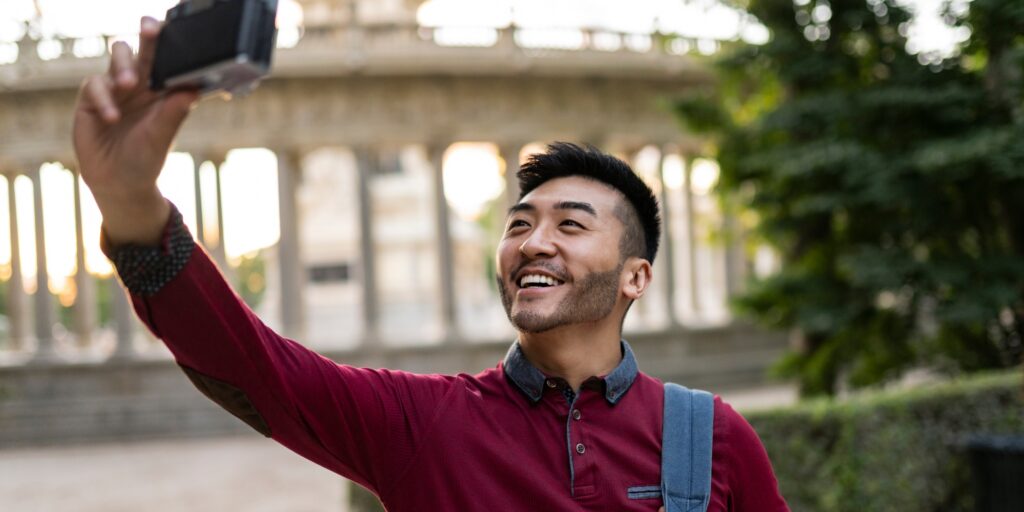 Happy asian tourist take a self portrait in the park