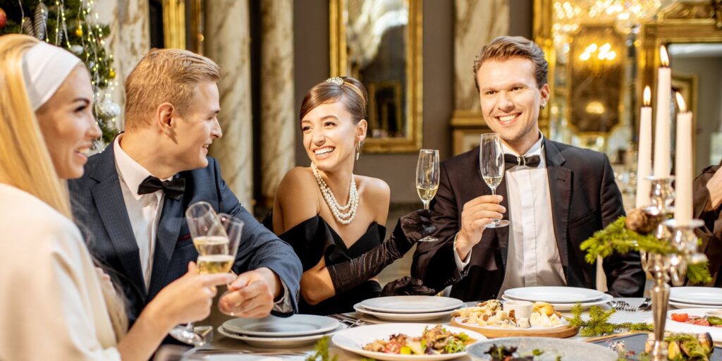 Elegantly dressed people having a festive dinner indoors