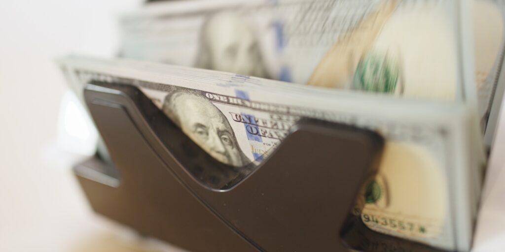 Money Counters count a stack of bills for 100 usd