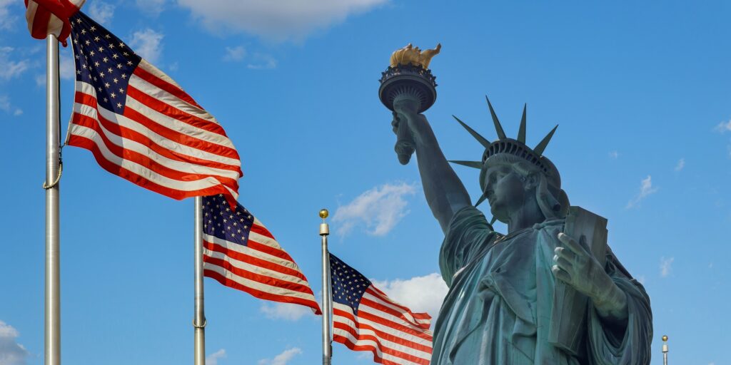 Statue of Liberty on the background flag United States New York, US