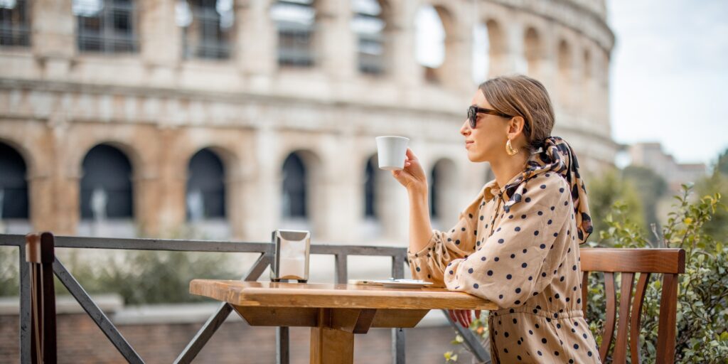 Woman at outdoor cafe in front of coliseum in Rome, Italy