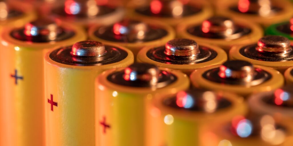 Closeup of positive ends of discharged batteries AA sizes, macro shot, selective focus. Used battery