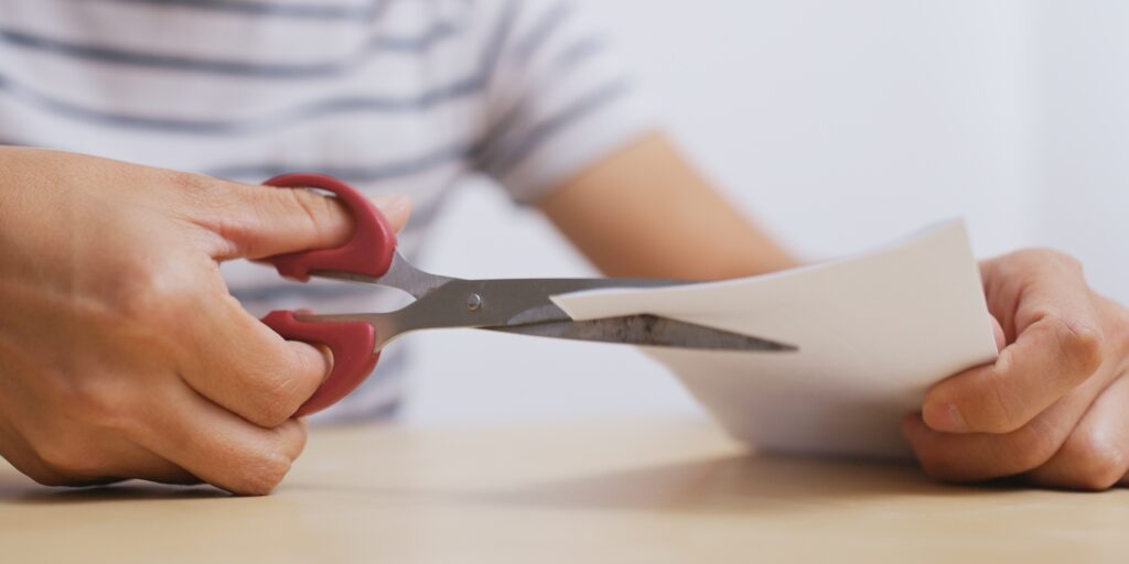 Man cutting paper by scissor