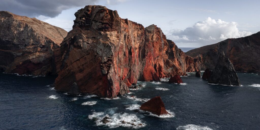 Waving sea near rough cliff