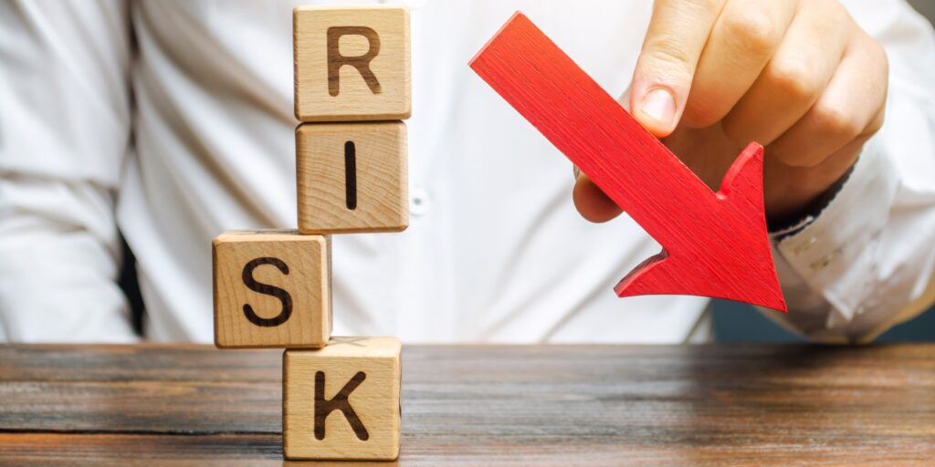 Wooden blocks with the word Risk and a down arrow