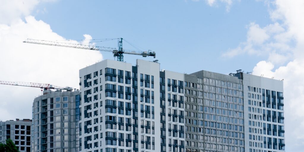 a urban landscape against the background of the summer sky high-rise new white houses construction
