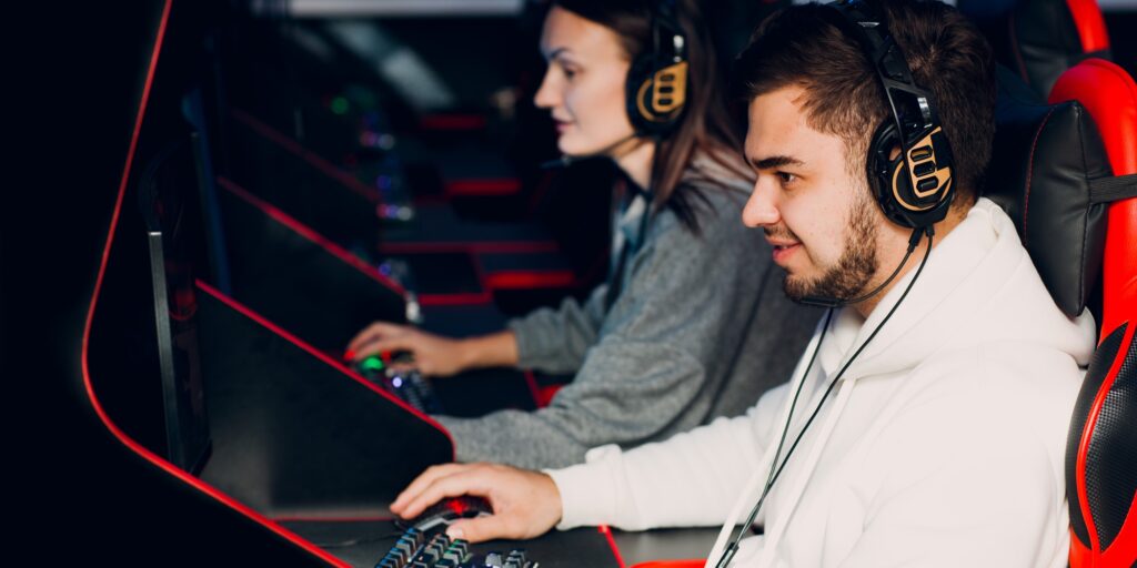 Guy playing gaming game on computer at game club