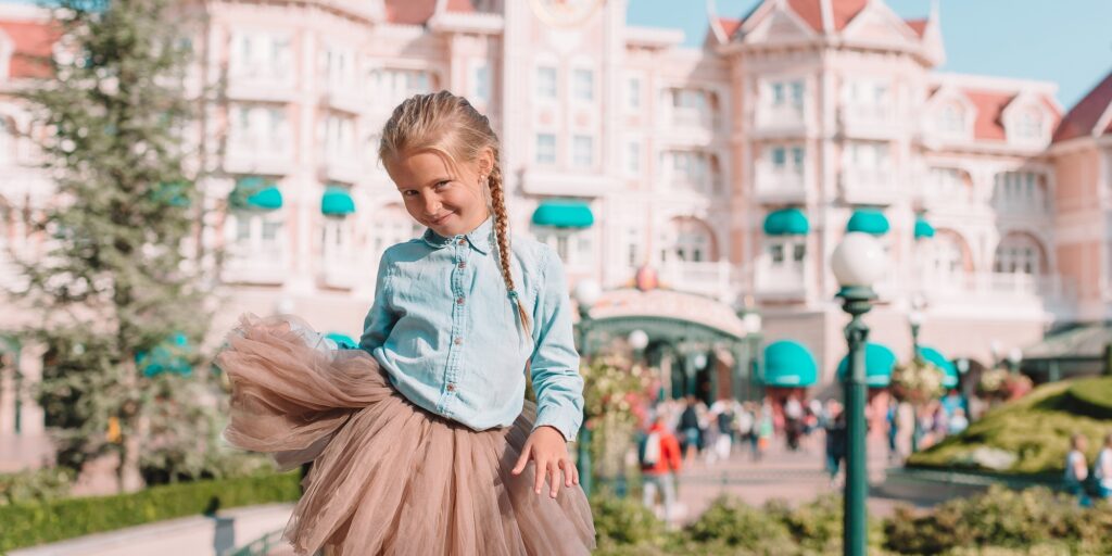 Little adorable girl in Cinderella dress at fairy-tale Disneyland park