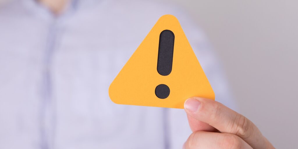 Man holding a yellow triangular warning sign