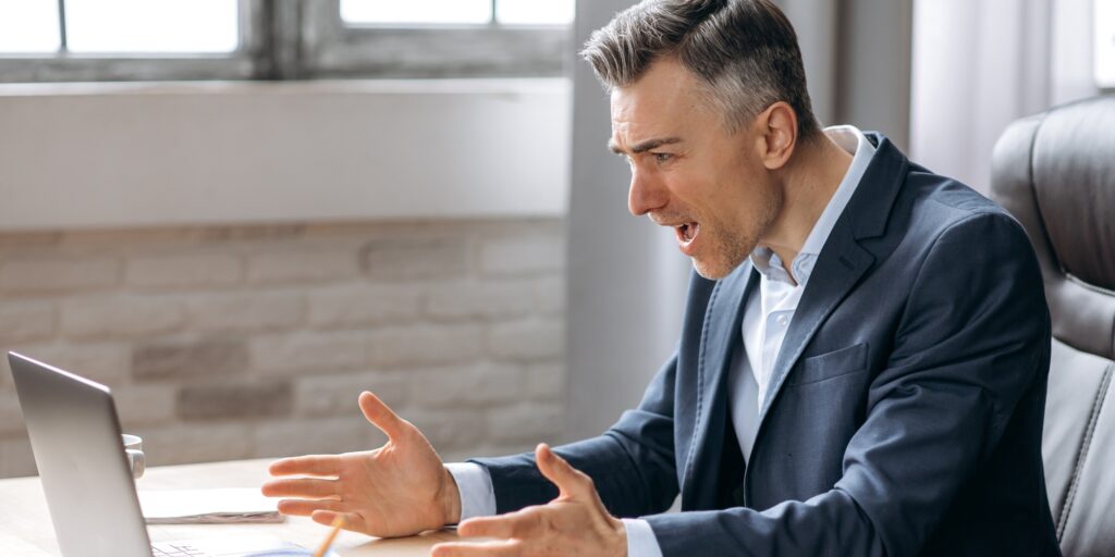 Outraged caucasian businessman, laptop, office