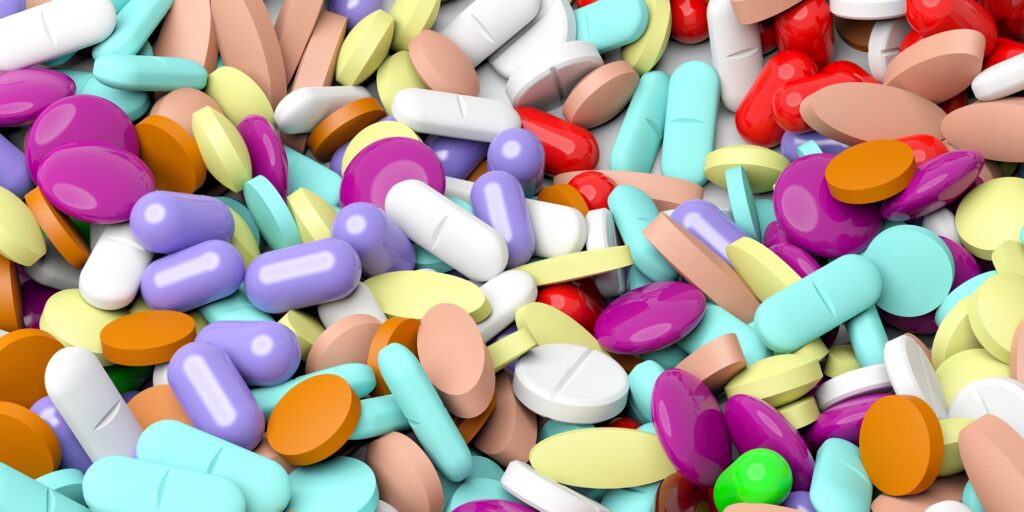 Pile of various colorful pills background.