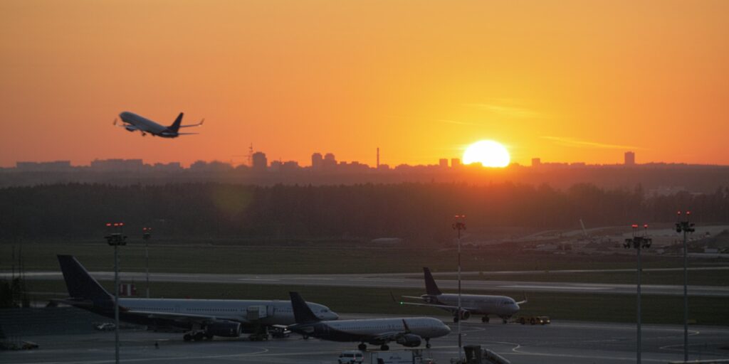 Airport view at golden sunset with an airplane taking off