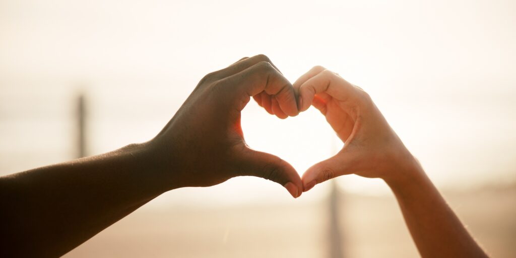 Heart, couple and hands outdoor with love, romance and bonding together with marriage on holiday. V