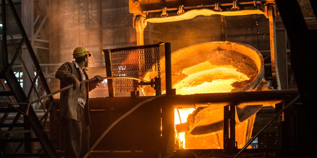 Steelworker at work near the tanks with hot metal